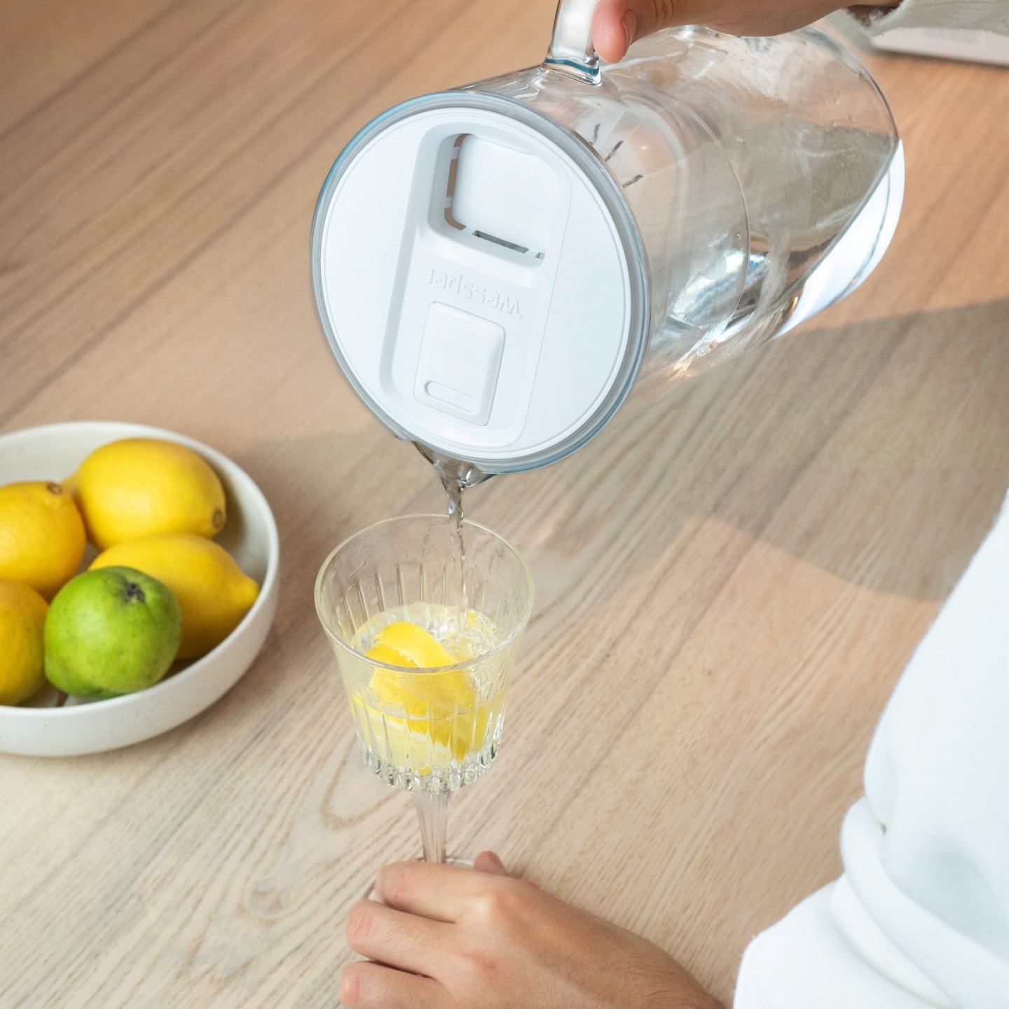 Dzbanek filtrujący Wessper wykorzystywany w kuchni - mężczyzna nalewa przefiltrowaną wodę do kieliszka